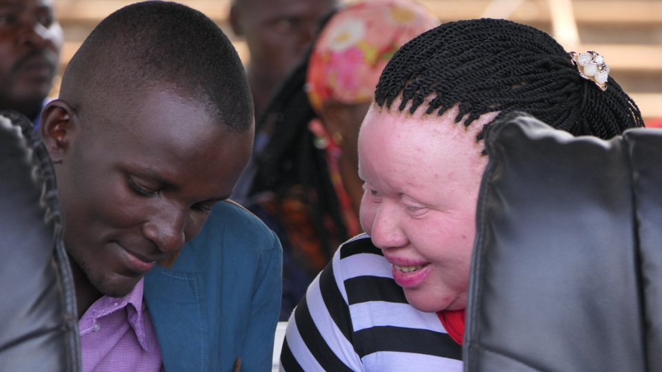 Allan Tenya Director GOBS Foundation speaks to a woman with albinism to see how they can work together in getting children with albinism back to school