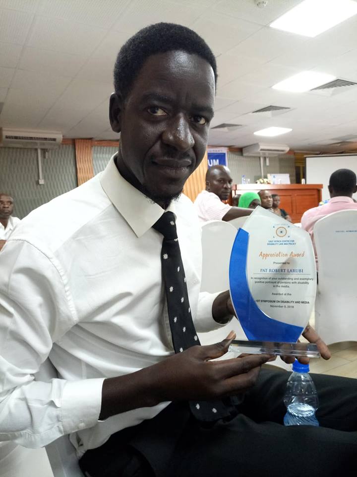 Pat displays his accolade for best reporting on disability inclusion in Uganda