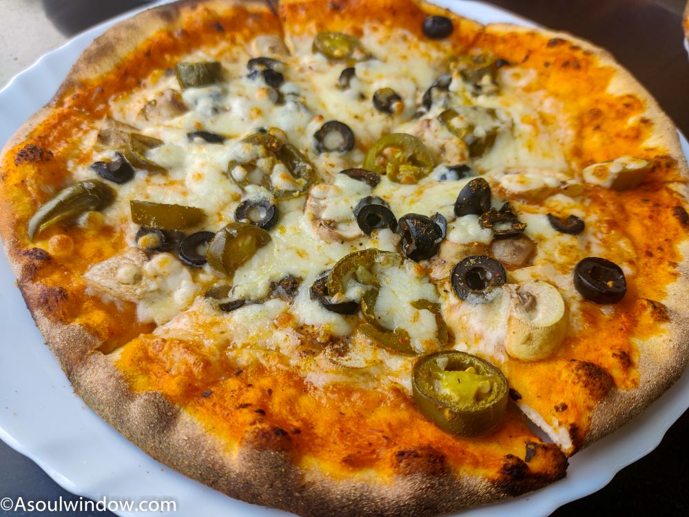 Wood fired olive, jalapeno & mushroom pizza at Assi ghat. Pizzeria Vaatika cafe. Varanasi